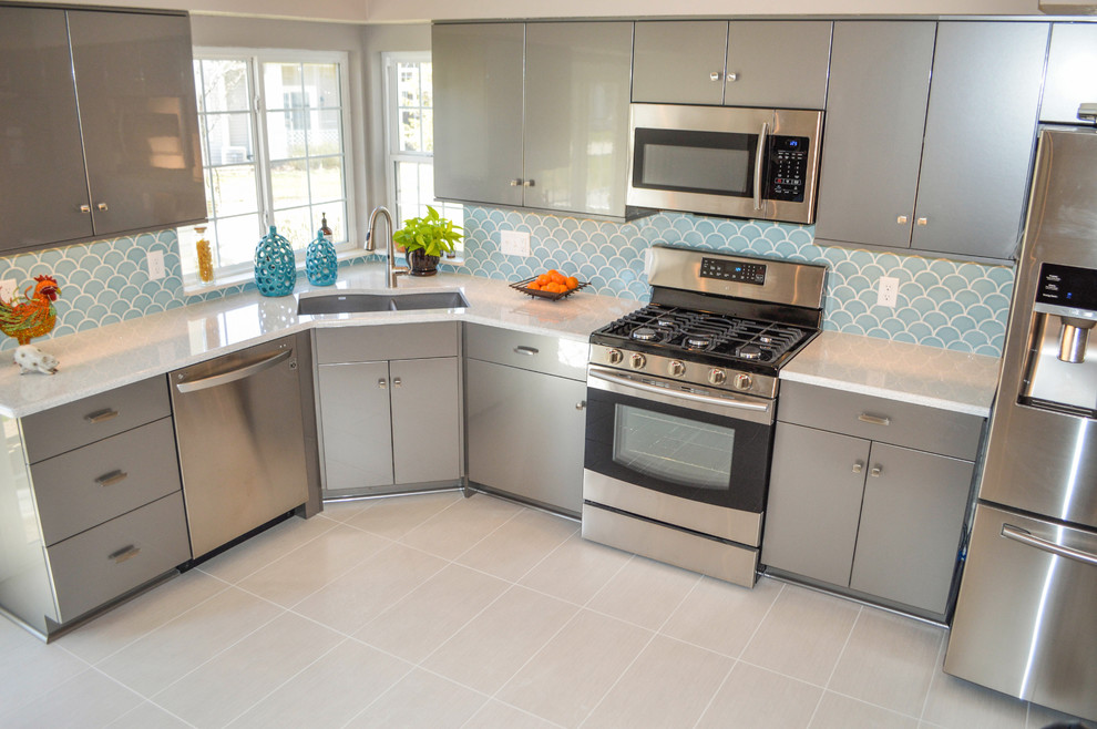 Mid-sized transitional u-shaped porcelain tile and gray floor enclosed kitchen photo in Cleveland with an undermount sink, flat-panel cabinets, gray cabinets, quartz countertops, blue backsplash, ceramic backsplash, stainless steel appliances, no island and white countertops