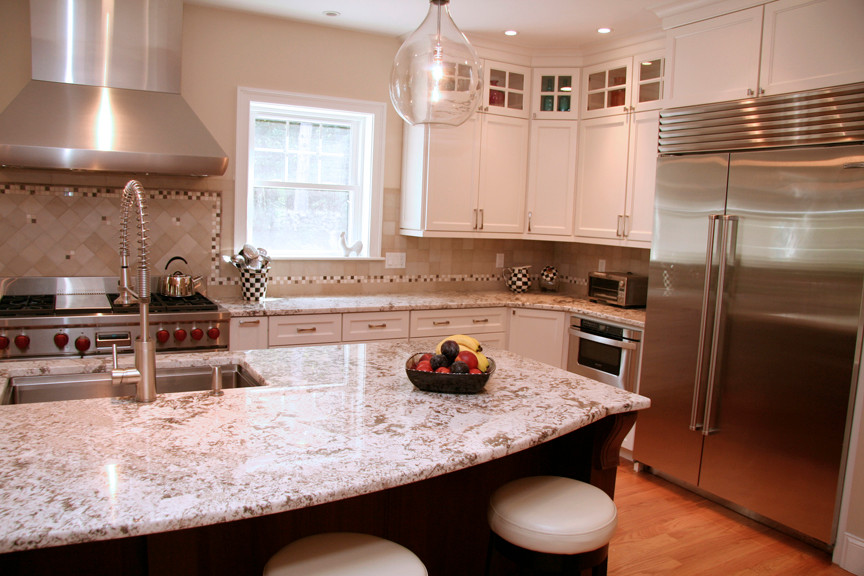 Exempel på ett stort klassiskt kök, med en undermonterad diskho, skåp i shakerstil, vita skåp, granitbänkskiva, beige stänkskydd, rostfria vitvaror, en köksö och mellanmörkt trägolv