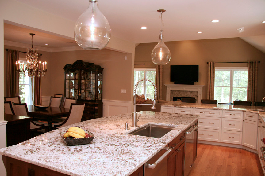 Example of a large transitional u-shaped medium tone wood floor eat-in kitchen design in Boston with an undermount sink, shaker cabinets, white cabinets, granite countertops, beige backsplash, stainless steel appliances and an island