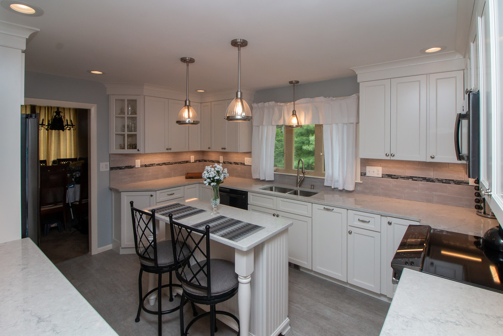 Inspiration for a mid-sized transitional u-shaped vinyl floor and gray floor eat-in kitchen remodel in Manchester with a double-bowl sink, recessed-panel cabinets, white cabinets, quartz countertops, gray backsplash, ceramic backsplash, stainless steel appliances, an island and white countertops