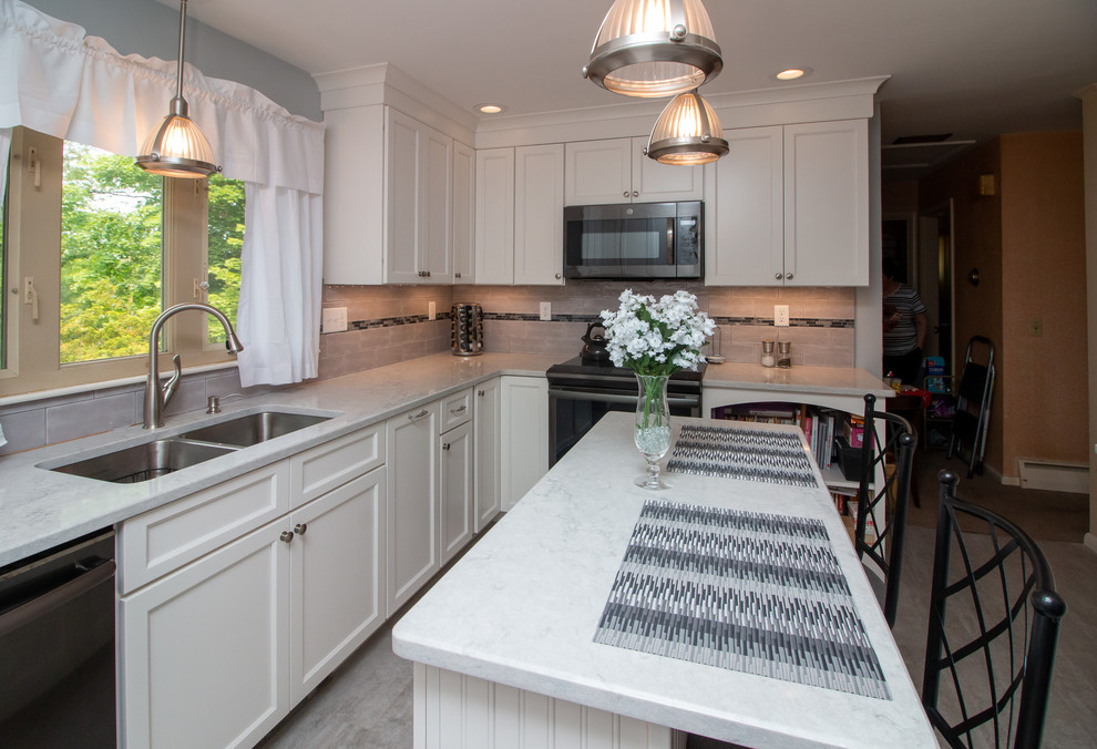 Eat-in kitchen - mid-sized transitional u-shaped vinyl floor and gray floor eat-in kitchen idea in Manchester with a double-bowl sink, recessed-panel cabinets, white cabinets, quartz countertops, gray backsplash, ceramic backsplash, stainless steel appliances, an island and white countertops
