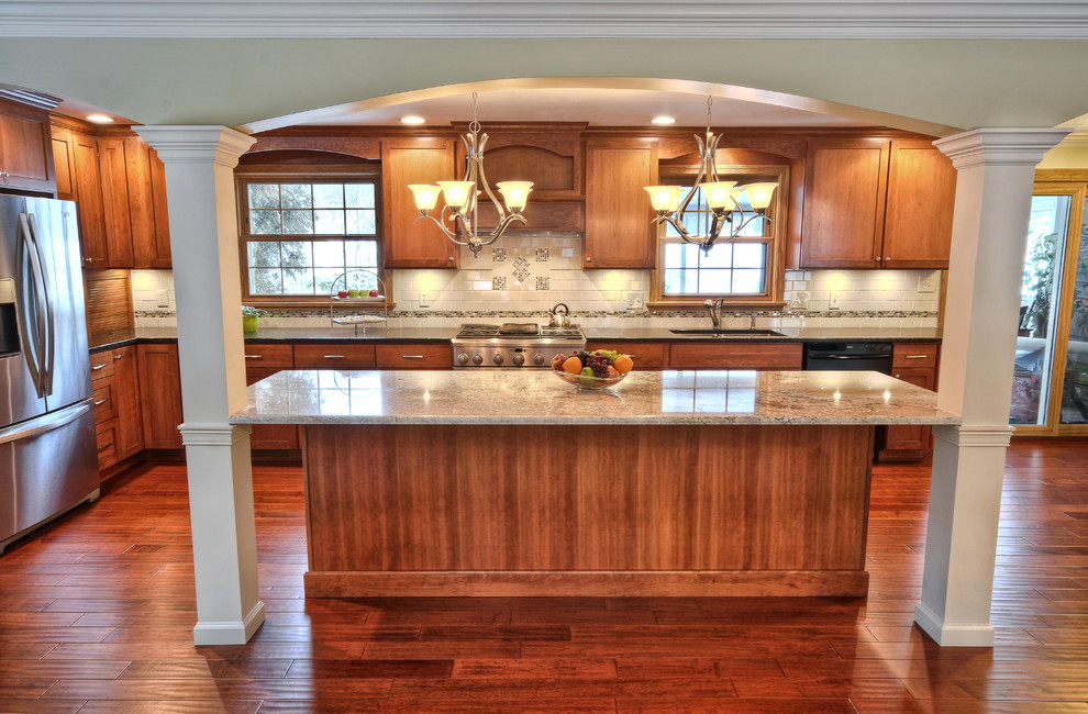 Exempel på ett klassiskt kök och matrum, med en dubbel diskho, skåp i shakerstil, skåp i mellenmörkt trä, bänkskiva i kvarts, beige stänkskydd, stänkskydd i mosaik, rostfria vitvaror och en köksö
