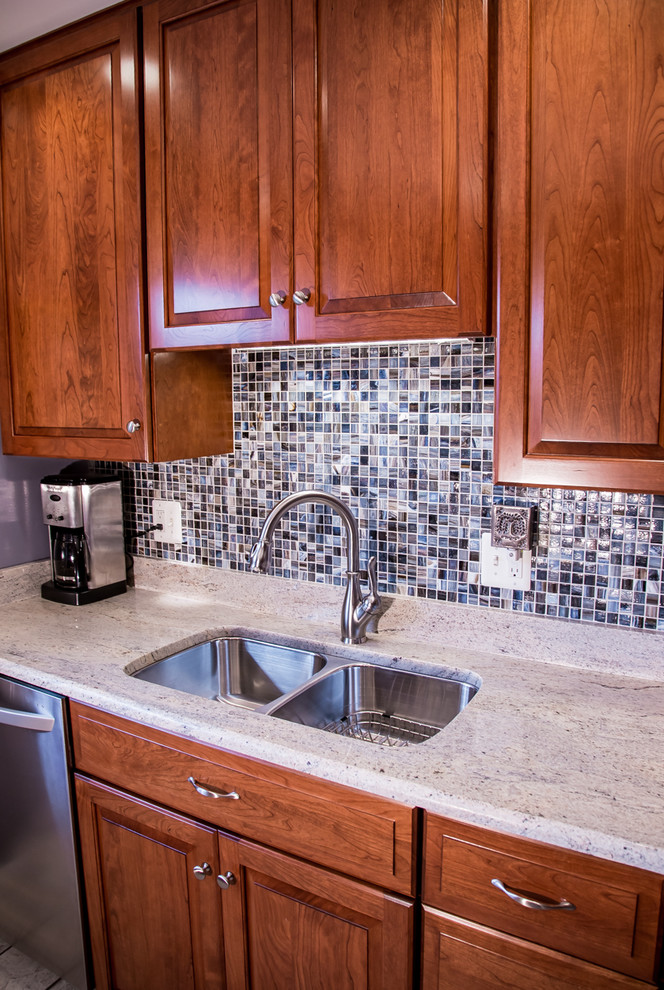 Inspiration for a mid-sized transitional single-wall ceramic tile eat-in kitchen remodel in Baltimore with a double-bowl sink, raised-panel cabinets, medium tone wood cabinets, blue backsplash, mosaic tile backsplash, stainless steel appliances, no island and soapstone countertops