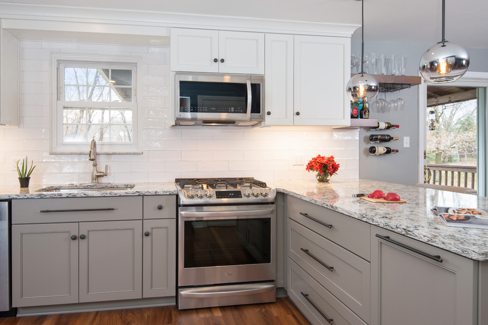 Example of a transitional l-shaped vinyl floor and brown floor eat-in kitchen design in Other with an undermount sink, beaded inset cabinets, white cabinets, quartz countertops, white backsplash, ceramic backsplash, stainless steel appliances and multicolored countertops