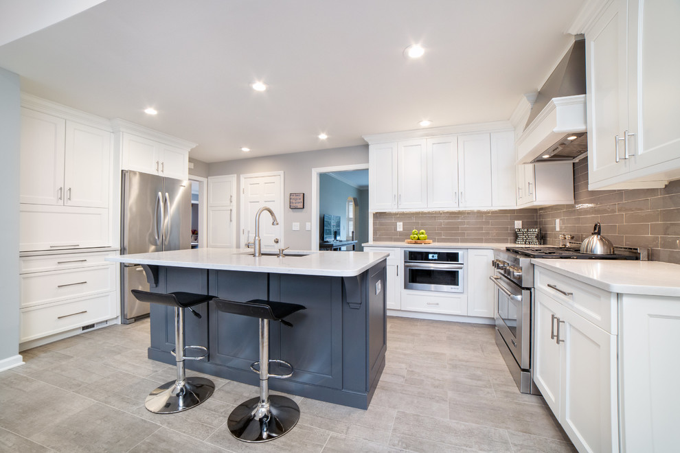 Example of a large transitional ceramic tile open concept kitchen design in New York with an undermount sink, shaker cabinets, white cabinets, quartz countertops, gray backsplash, ceramic backsplash, stainless steel appliances and an island