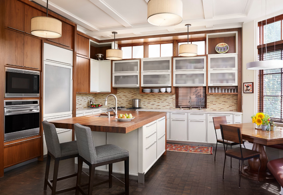 Inspiration for a transitional l-shaped eat-in kitchen remodel in Chicago with glass-front cabinets, white cabinets, wood countertops, beige backsplash and stainless steel appliances