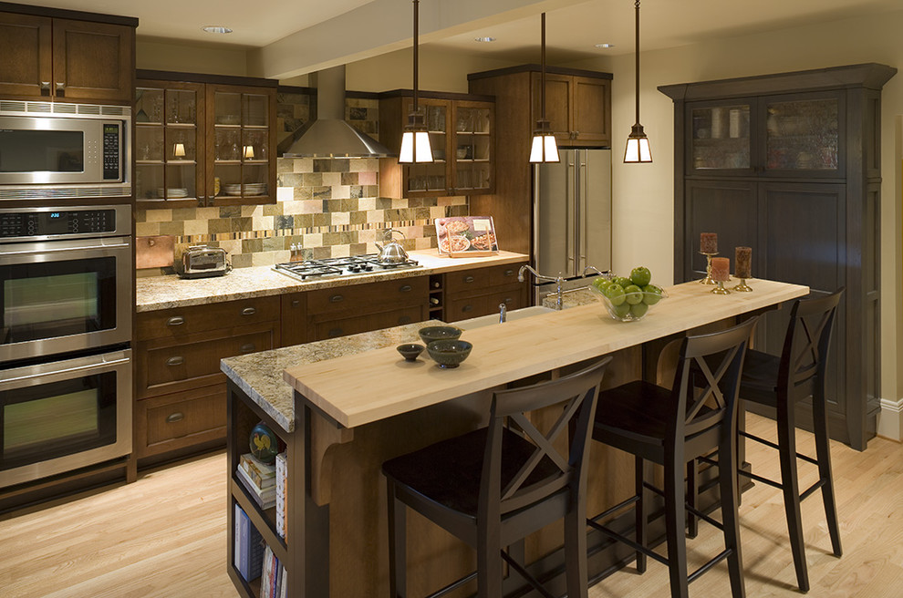 Inspiration for a timeless galley kitchen remodel in Portland with glass-front cabinets, stainless steel appliances, granite countertops, dark wood cabinets and multicolored backsplash