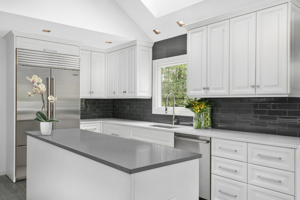 Esempio di un cucina con isola centrale chic con ante bianche, paraspruzzi grigio, elettrodomestici in acciaio inossidabile e pavimento grigio
