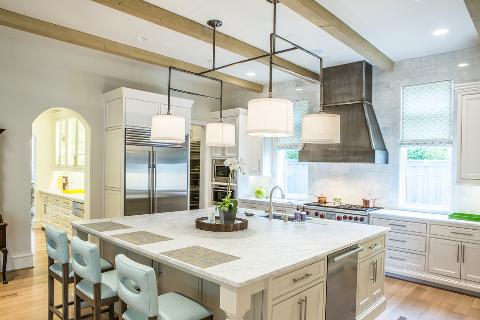 Example of a transitional l-shaped light wood floor kitchen design in Dallas with an undermount sink, beaded inset cabinets, white cabinets, marble countertops, white backsplash, stainless steel appliances and an island