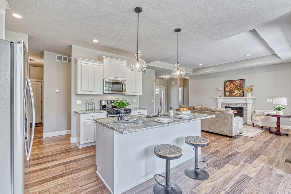 Eat-in kitchen - large transitional l-shaped medium tone wood floor and multicolored floor eat-in kitchen idea in New York with an undermount sink, raised-panel cabinets, gray cabinets, granite countertops, stainless steel appliances, an island and multicolored countertops