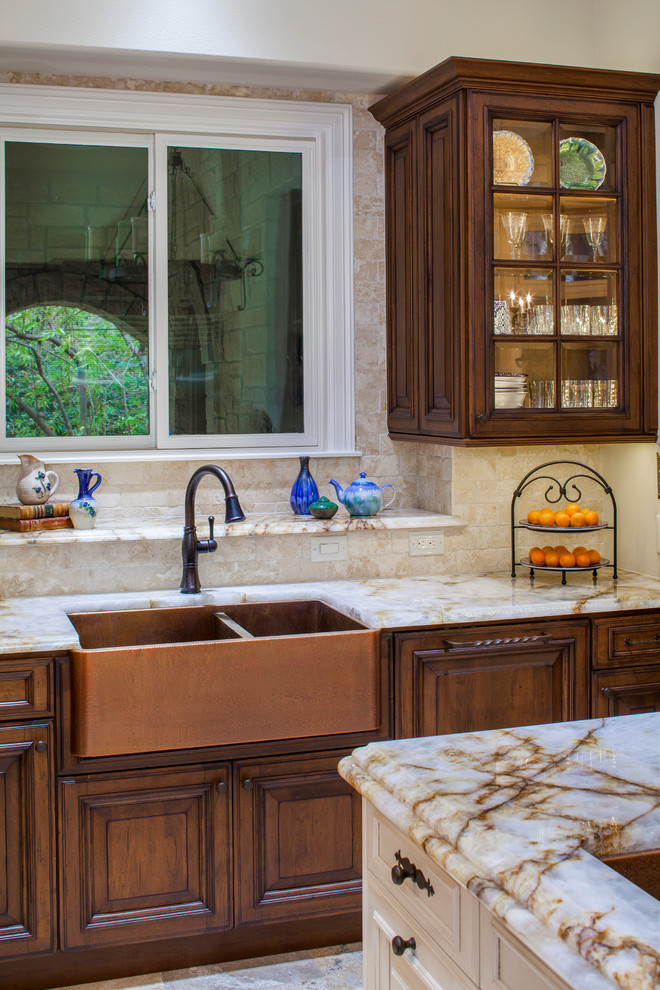 Transitional kitchen photo in Austin with a farmhouse sink, dark wood cabinets, granite countertops, beige backsplash, ceramic backsplash, stainless steel appliances and an island