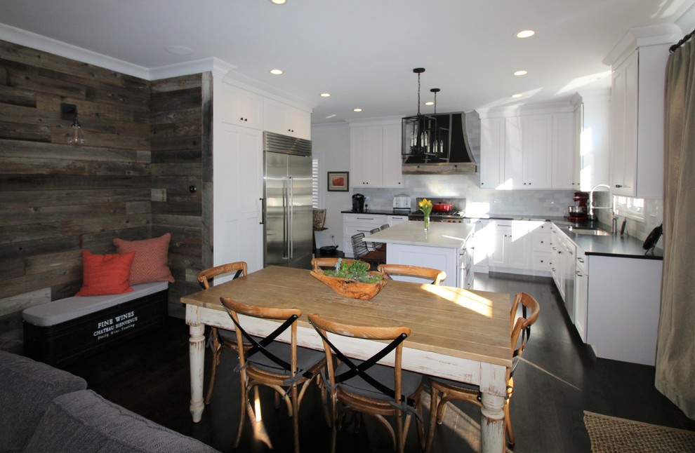 Exempel på ett avskilt, mellanstort klassiskt svart svart l-kök, med en undermonterad diskho, luckor med infälld panel, vita skåp, bänkskiva i täljsten, grått stänkskydd, stänkskydd i marmor, rostfria vitvaror, mörkt trägolv, en köksö och svart golv