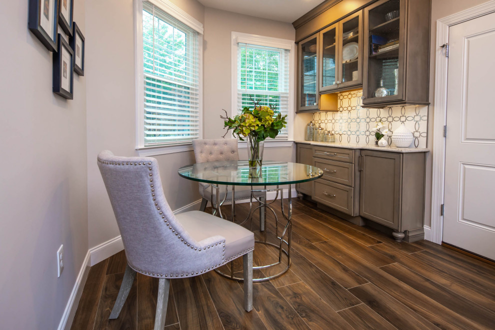 Inspiration for a mid-sized transitional single-wall porcelain tile and brown floor eat-in kitchen remodel in New York with an undermount sink, glass-front cabinets, gray cabinets, quartz countertops, white backsplash, marble backsplash, stainless steel appliances and multicolored countertops