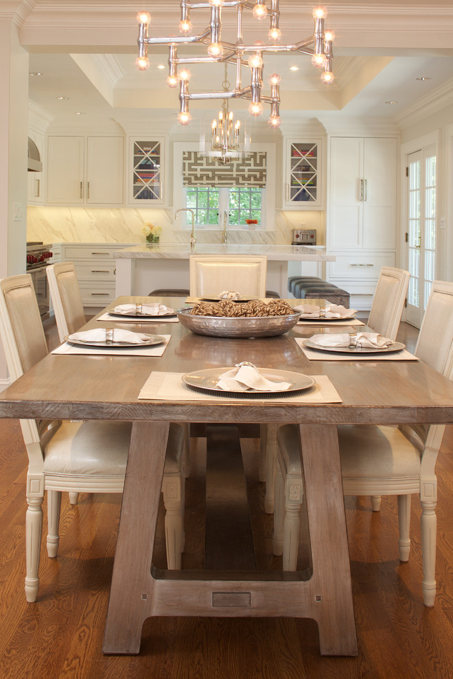 This is an example of a large classic u-shaped kitchen/diner in New York with white cabinets, stone slab splashback, integrated appliances, medium hardwood flooring, an island, a submerged sink, recessed-panel cabinets and marble worktops.