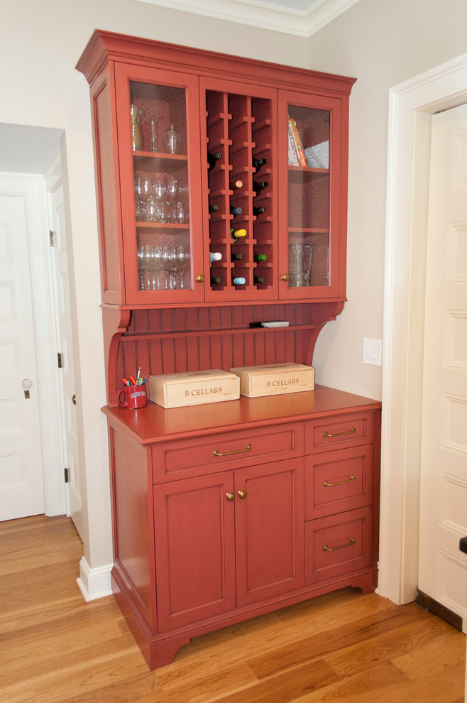 Diseño de cocina tradicional renovada de tamaño medio con armarios con paneles empotrados, suelo de madera en tonos medios, puertas de armario rojas y encimera de madera