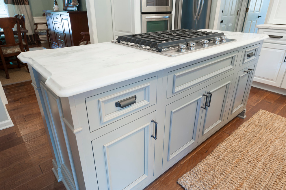 Inredning av ett klassiskt mellanstort kök, med en enkel diskho, luckor med upphöjd panel, vita skåp, marmorbänkskiva, grått stänkskydd, rostfria vitvaror, mörkt trägolv och en köksö