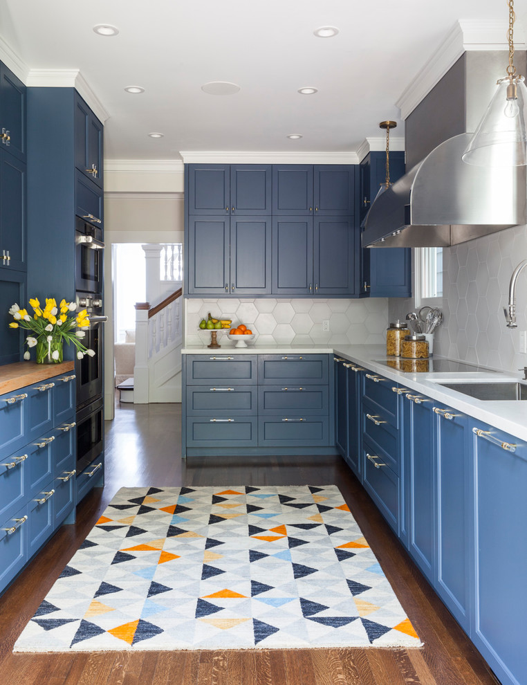 This is an example of a traditional u-shaped kitchen in San Francisco with a submerged sink, shaker cabinets, blue cabinets, white splashback, integrated appliances, dark hardwood flooring, no island and brown floors.