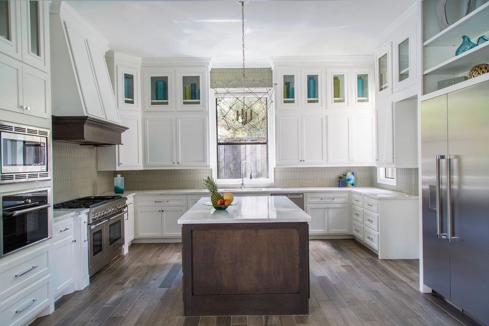 Mid-sized transitional u-shaped dark wood floor and brown floor open concept kitchen photo in Other with an undermount sink, shaker cabinets, white cabinets, marble countertops, beige backsplash, matchstick tile backsplash, stainless steel appliances and two islands