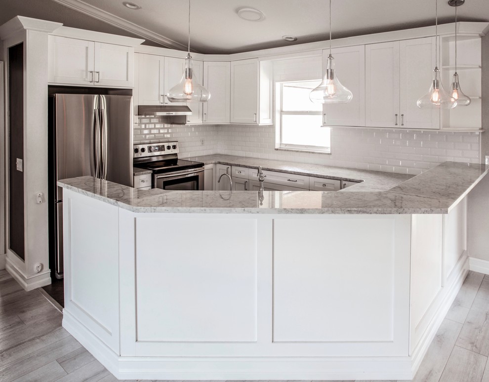 Inredning av ett klassiskt litet grå grått kök, med en undermonterad diskho, skåp i shakerstil, vita skåp, marmorbänkskiva, vitt stänkskydd, stänkskydd i tunnelbanekakel, rostfria vitvaror, ljust trägolv och grått golv