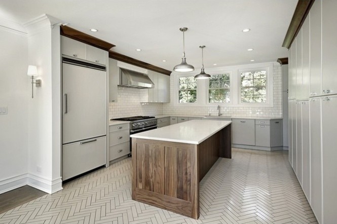 Photo of a medium sized classic l-shaped enclosed kitchen in Chicago with flat-panel cabinets, white cabinets, stainless steel appliances, an island, a submerged sink, engineered stone countertops, white splashback, glass tiled splashback and ceramic flooring.