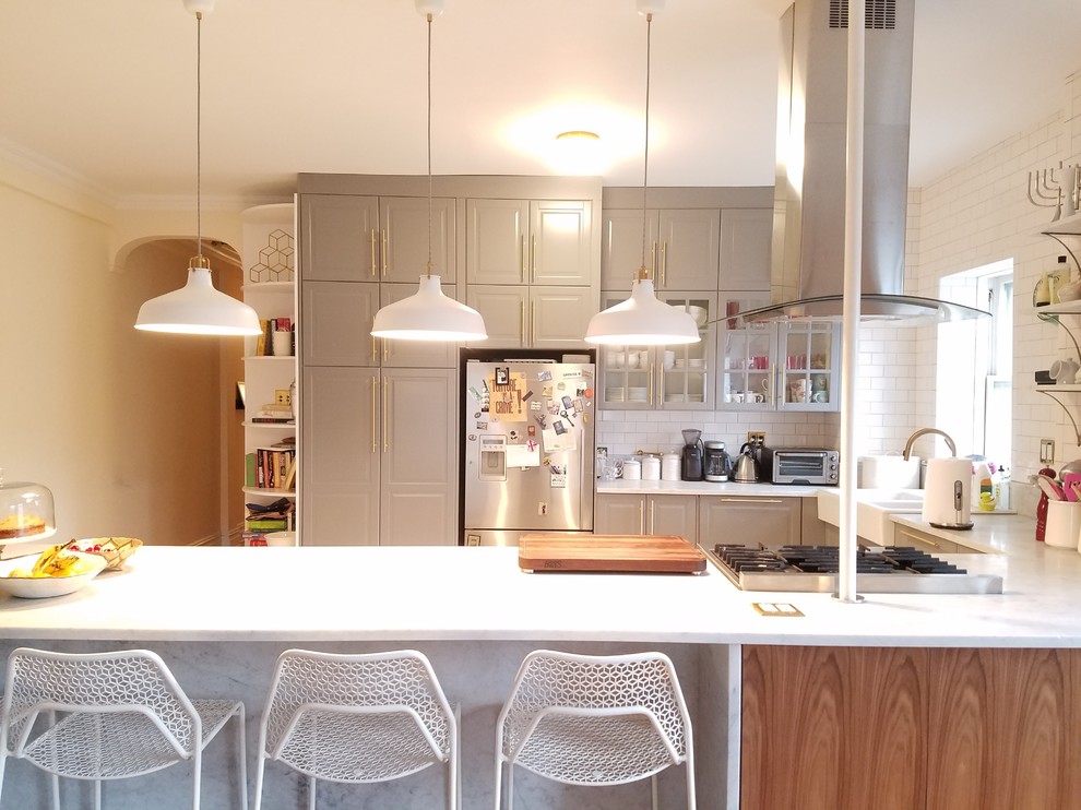 Bild på ett stort vintage kök, med en rustik diskho, luckor med upphöjd panel, grå skåp, bänkskiva i kvarts, vitt stänkskydd, stänkskydd i tunnelbanekakel, rostfria vitvaror, mellanmörkt trägolv och en halv köksö