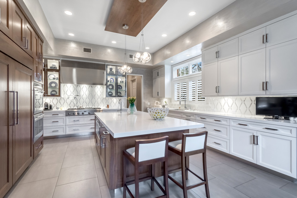 Photo of a medium sized traditional u-shaped kitchen in New York with recessed-panel cabinets, white cabinets, white splashback, stainless steel appliances, an island, a submerged sink, composite countertops, porcelain flooring and mosaic tiled splashback.