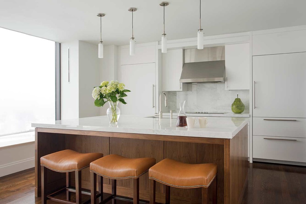 Inspiration for a mid-sized transitional l-shaped dark wood floor eat-in kitchen remodel in Boston with an undermount sink, flat-panel cabinets, white cabinets, white backsplash, stainless steel appliances, an island, marble countertops and stone slab backsplash