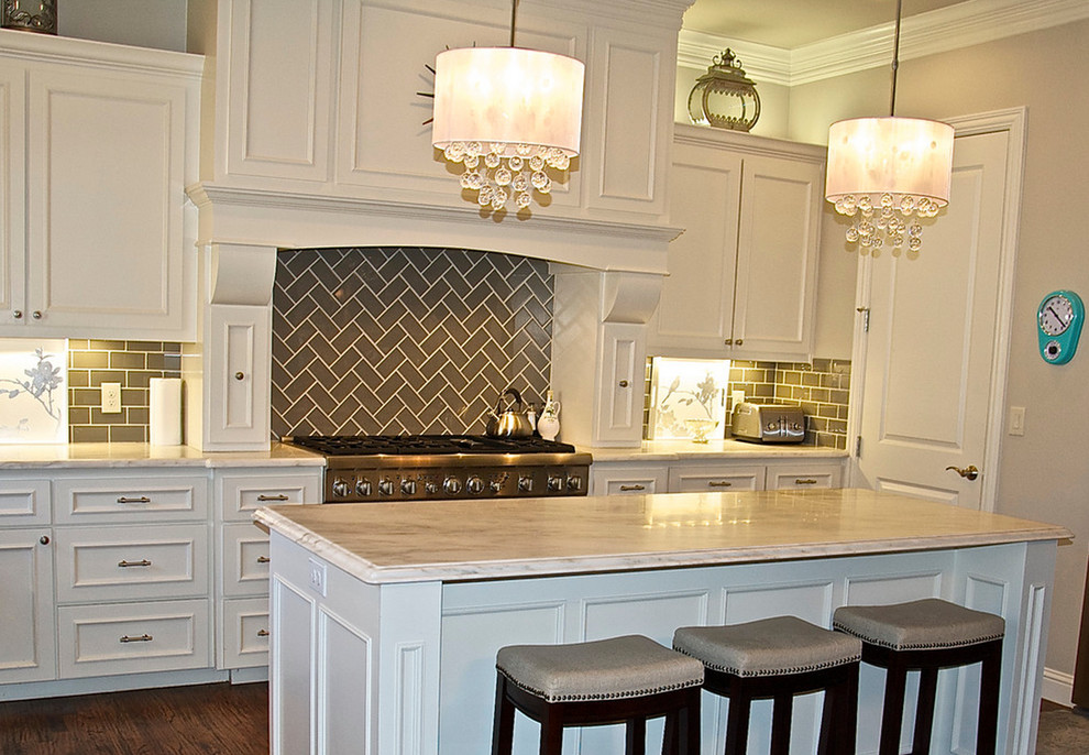 Bild på ett mellanstort vintage kök, med luckor med infälld panel, vita skåp, marmorbänkskiva, brunt stänkskydd, stänkskydd i tunnelbanekakel, rostfria vitvaror, mörkt trägolv och en köksö