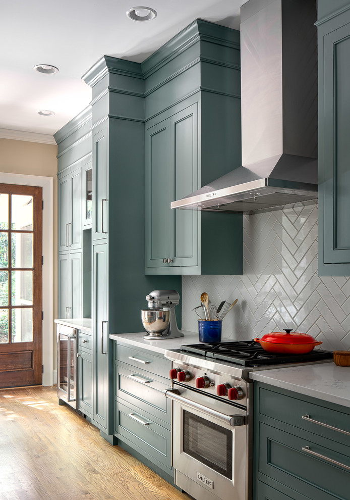 Exempel på ett stort klassiskt flerfärgad flerfärgat kök, med en undermonterad diskho, luckor med infälld panel, blå skåp, bänkskiva i kvarts, grått stänkskydd, stänkskydd i keramik, rostfria vitvaror, ljust trägolv och brunt golv
