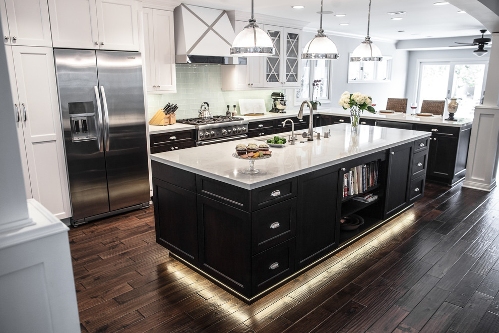 Large transitional dark wood floor kitchen photo in Los Angeles with an undermount sink, recessed-panel cabinets, black cabinets, quartz countertops, green backsplash, subway tile backsplash, stainless steel appliances and an island