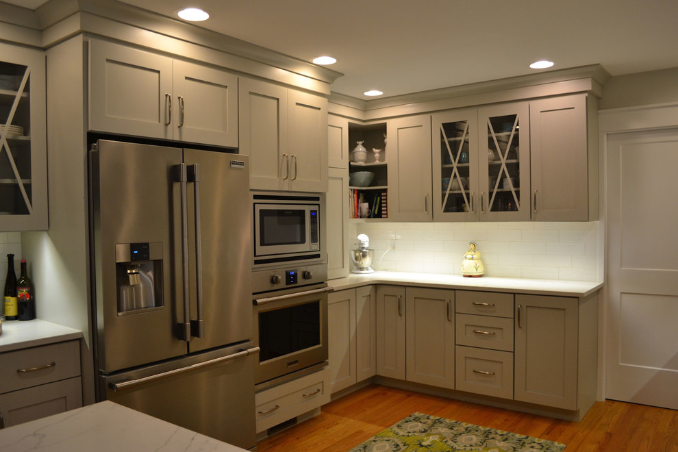 Foto på ett mellanstort vintage vit kök, med en rustik diskho, skåp i shakerstil, grå skåp, granitbänkskiva, vitt stänkskydd, stänkskydd i keramik, rostfria vitvaror, mellanmörkt trägolv och brunt golv