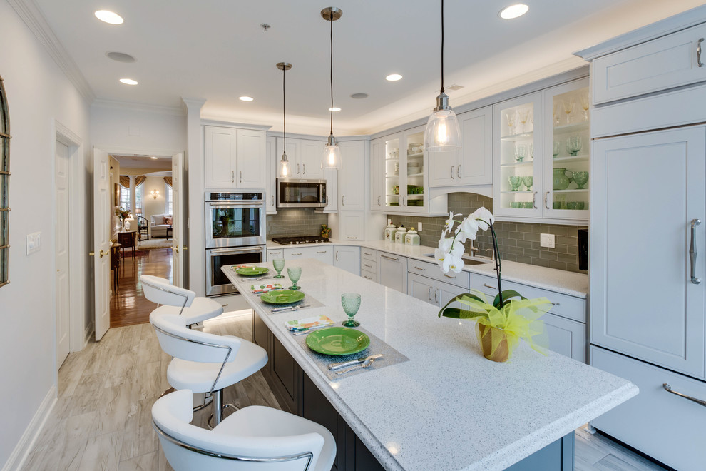 Large transitional l-shaped kitchen photo in DC Metro with an undermount sink, raised-panel cabinets, quartz countertops, green backsplash, subway tile backsplash and an island