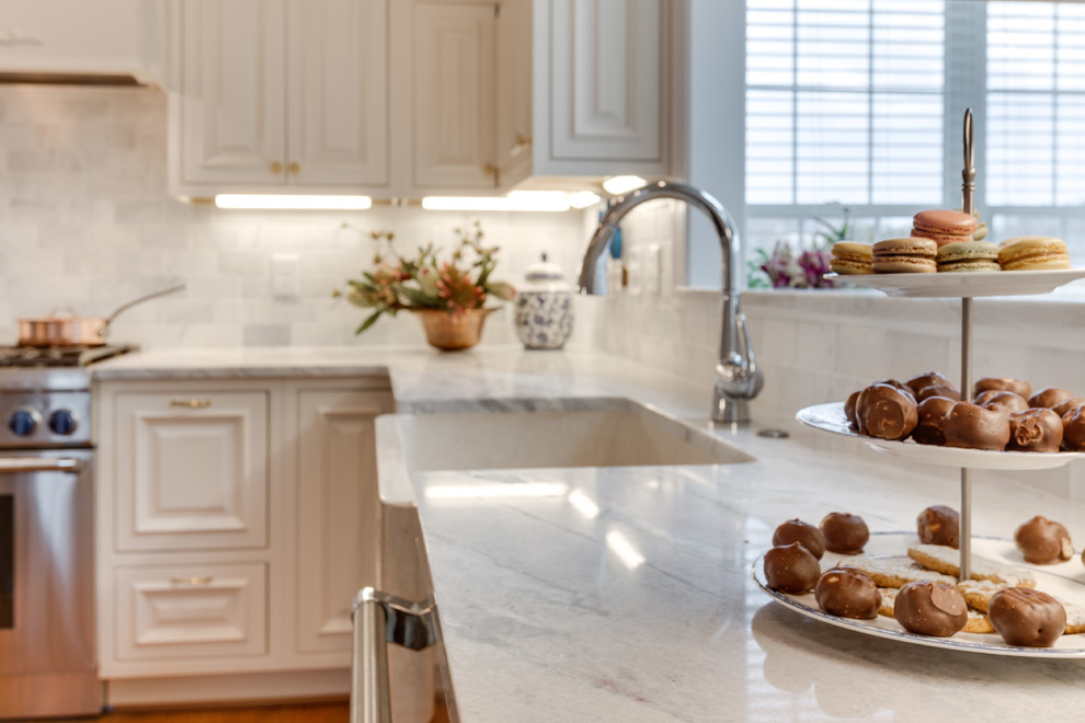 Große Klassische Küche mit Kassettenfronten, Marmor-Arbeitsplatte, Küchengeräten aus Edelstahl, braunem Holzboden und Kücheninsel in Washington, D.C.