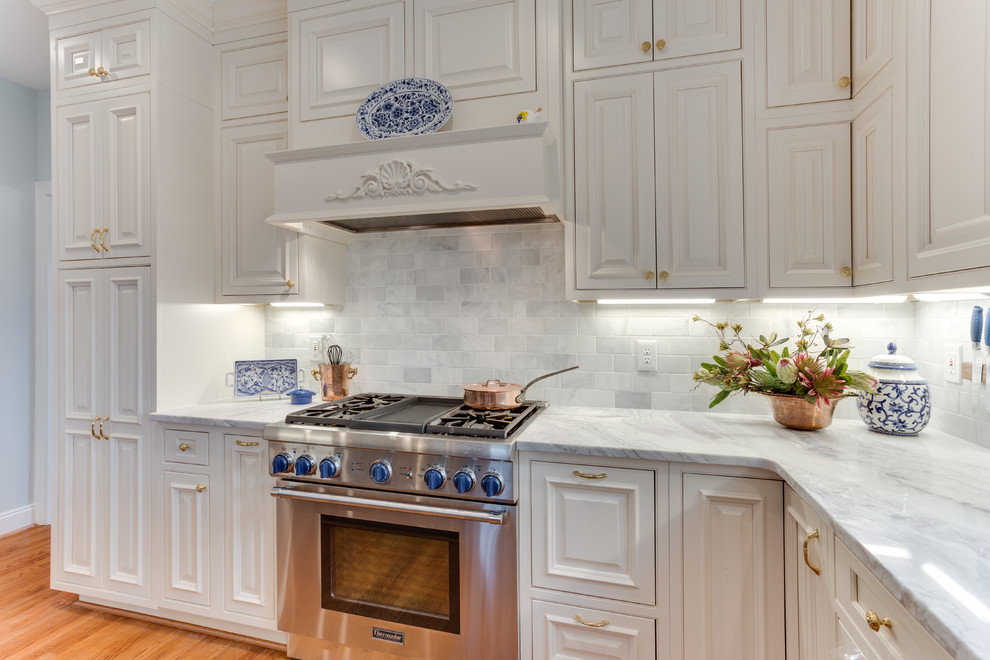 ワシントンD.C.にある広いトランジショナルスタイルのおしゃれなアイランドキッチン (インセット扉のキャビネット、大理石カウンター、シルバーの調理設備、無垢フローリング) の写真