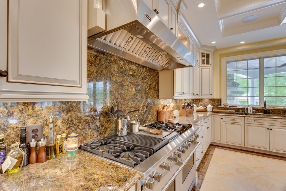 Immagine di un'ampia cucina chic con lavello sottopiano, ante con bugna sagomata, top in granito e elettrodomestici in acciaio inossidabile