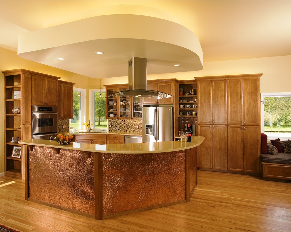 Klassisk inredning av ett kök med öppen planlösning, med luckor med infälld panel, rostfria vitvaror, skåp i mellenmörkt trä och flerfärgad stänkskydd