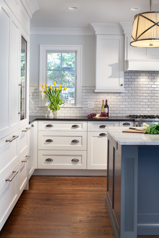 Inspiration for a large classic u-shaped kitchen/diner in Detroit with white cabinets, an island, recessed-panel cabinets, white splashback, ceramic splashback, stainless steel appliances, dark hardwood flooring and marble worktops.