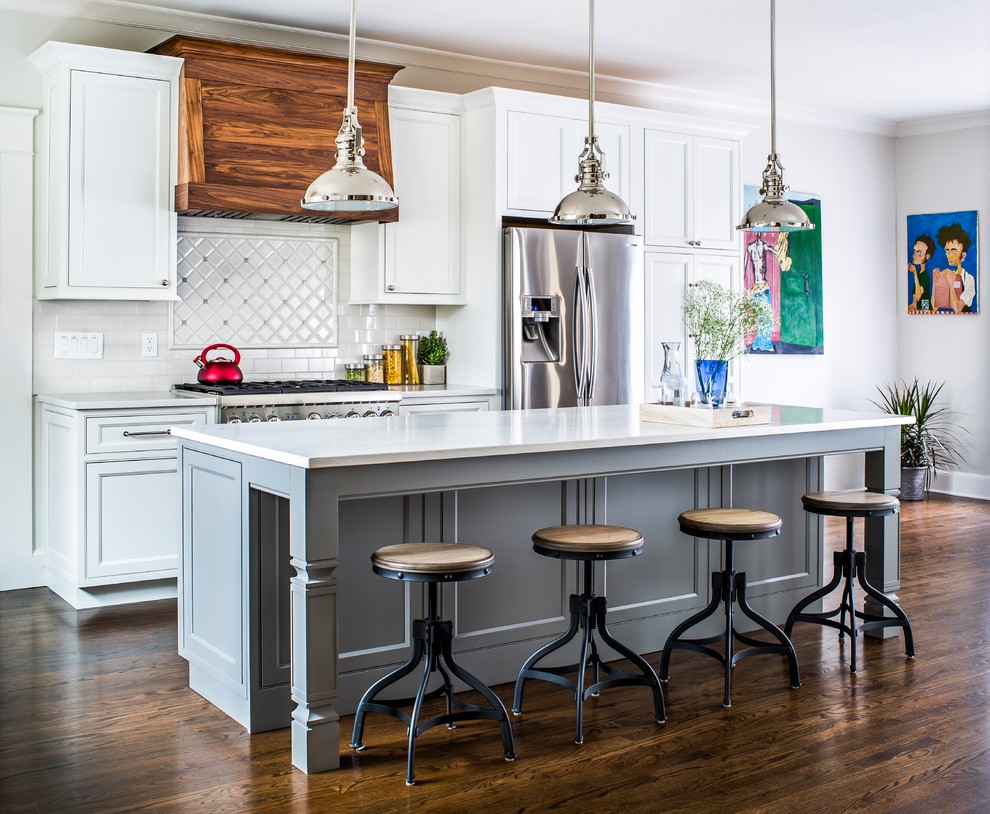 Transitional galley dark wood floor open concept kitchen photo in Philadelphia with recessed-panel cabinets, white cabinets, white backsplash, stainless steel appliances and an island