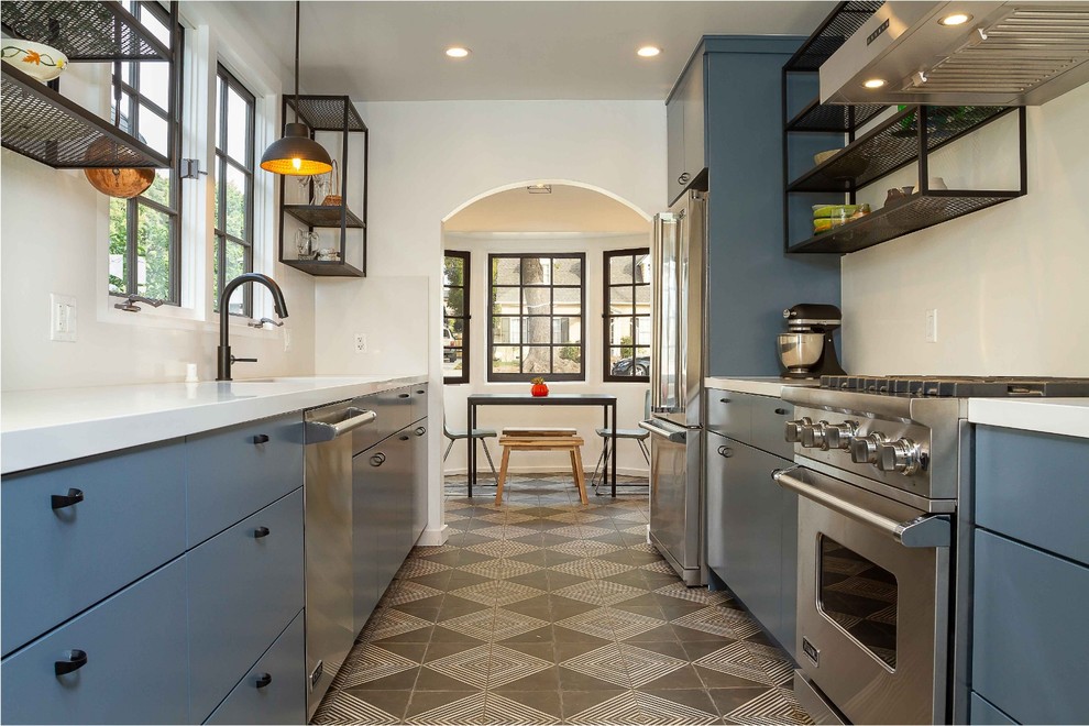 Eat-in kitchen - transitional galley brown floor eat-in kitchen idea in Los Angeles with an undermount sink, flat-panel cabinets, blue cabinets, white backsplash, stainless steel appliances and white countertops