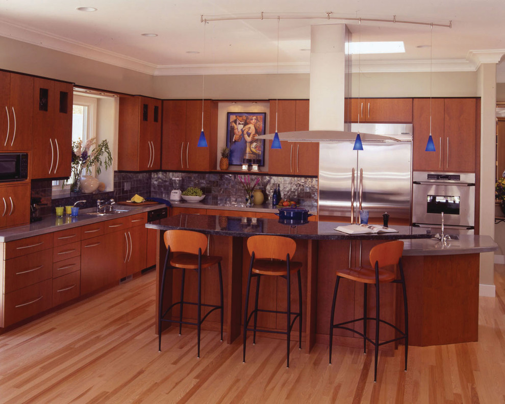 サンフランシスコにある高級な中くらいなコンテンポラリースタイルのおしゃれなキッチン (一体型シンク、フラットパネル扉のキャビネット、中間色木目調キャビネット、御影石カウンター、グレーのキッチンパネル、スレートのキッチンパネル、シルバーの調理設備、淡色無垢フローリング、ベージュの床) の写真