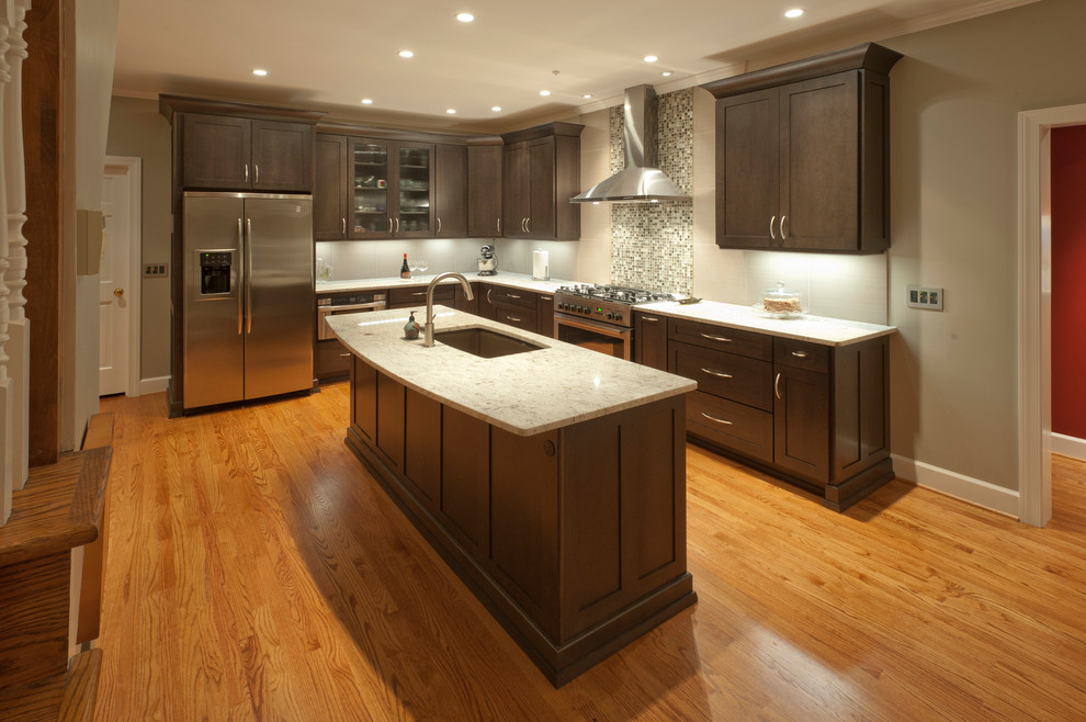 Large transitional l-shaped medium tone wood floor enclosed kitchen photo in Atlanta with an undermount sink, shaker cabinets, dark wood cabinets, quartz countertops, multicolored backsplash, mosaic tile backsplash, stainless steel appliances and an island