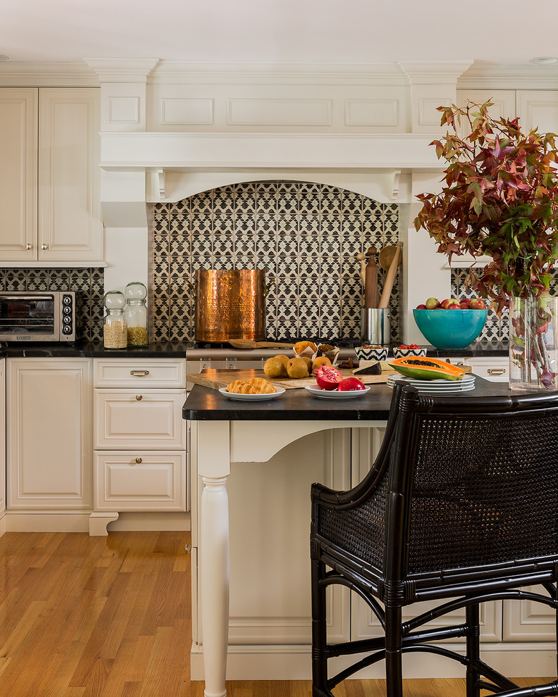 Cette image montre une cuisine traditionnelle avec un placard avec porte à panneau surélevé et une crédence multicolore.