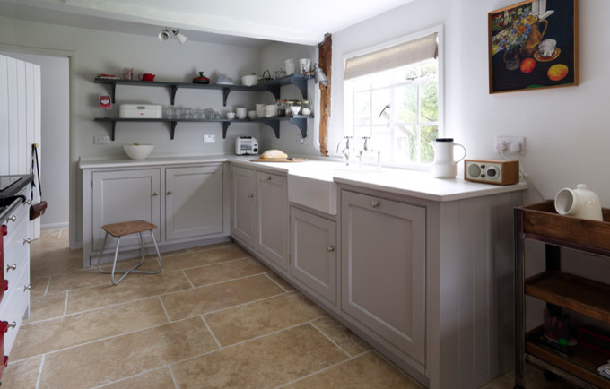 Photo of a small classic galley enclosed kitchen in Essex with a belfast sink, grey cabinets, granite worktops, flat-panel cabinets, stainless steel appliances, travertine flooring and no island.