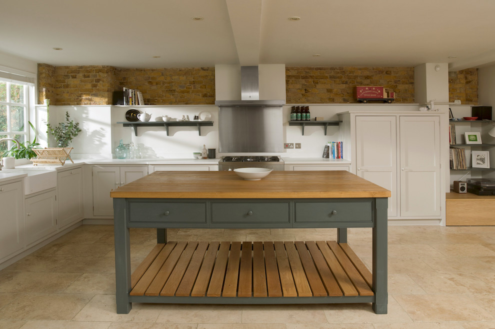 Exempel på ett mellanstort klassiskt kök, med en rustik diskho, släta luckor, grå skåp, granitbänkskiva, stänkskydd med metallisk yta, rostfria vitvaror, travertin golv och en köksö