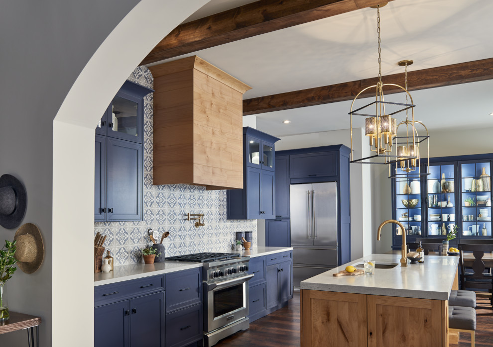 Пример оригинального дизайна: большая угловая кухня в стиле неоклассика (современная классика) с врезной мойкой, фасадами в стиле шейкер, синими фасадами, синим фартуком, фартуком из плитки мозаики, техникой из нержавеющей стали, островом, коричневым полом и серой столешницей