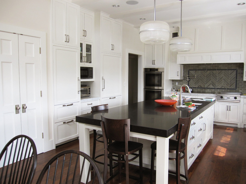 Cette photo montre une cuisine américaine encastrable chic avec un placard à porte shaker, des portes de placard blanches, un plan de travail en granite, une crédence grise et une crédence en ardoise.