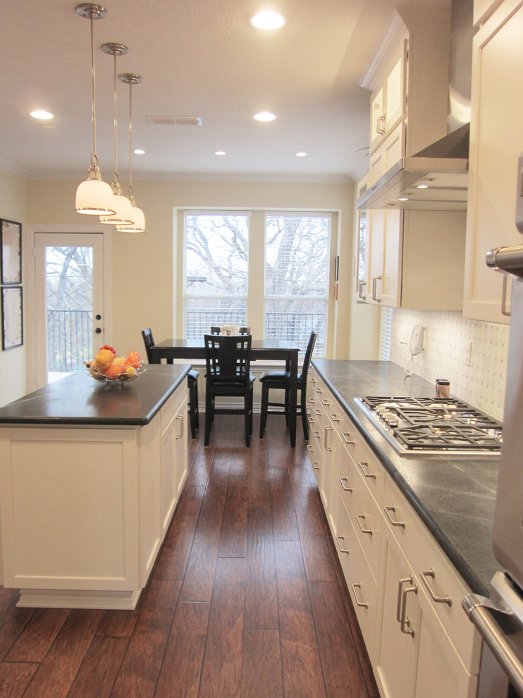 他の地域にある広いトランジショナルスタイルのおしゃれなキッチン (白いキャビネット、濃色無垢フローリング、落し込みパネル扉のキャビネット、白いキッチンパネル、シルバーの調理設備) の写真