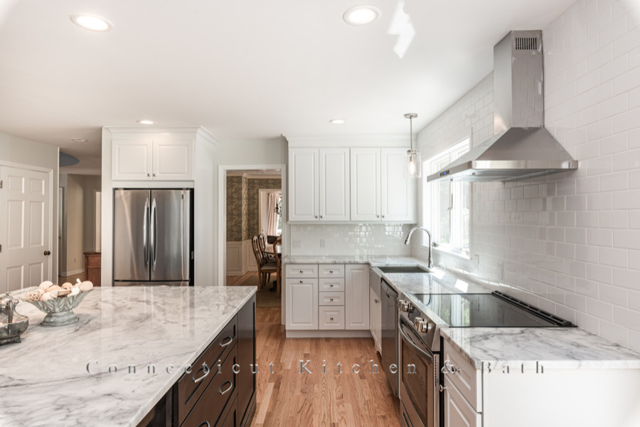 Klassische Wohnküche mit Küchenrückwand in Weiß, Küchengeräten aus Edelstahl, Kücheninsel und bunter Arbeitsplatte in New York
