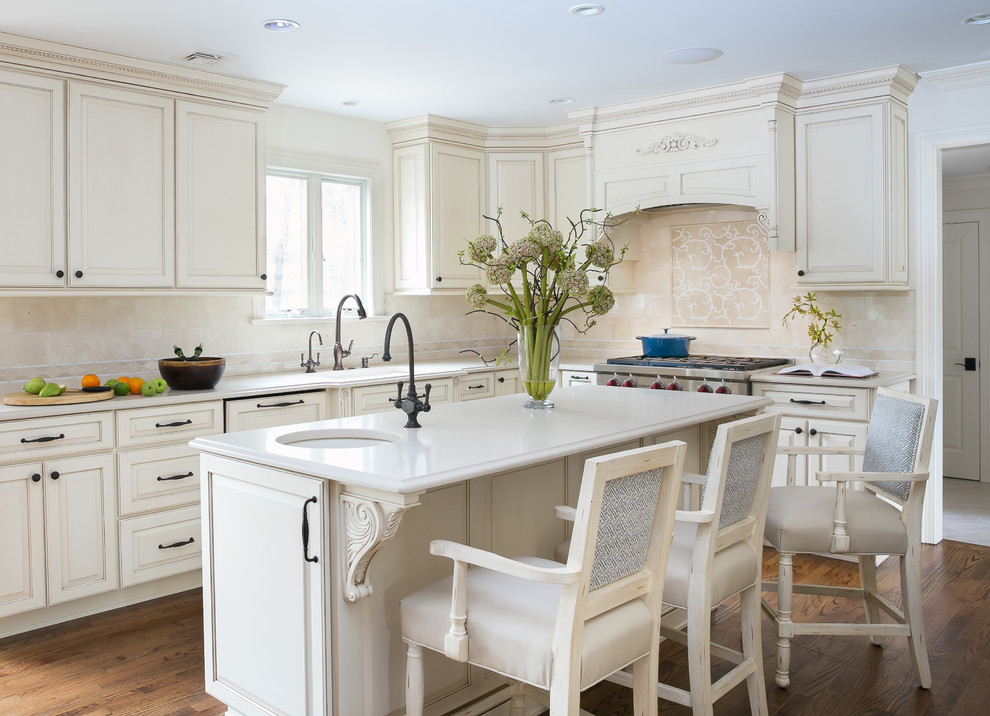 Inspiration for a large timeless u-shaped medium tone wood floor and brown floor eat-in kitchen remodel in Newark with an undermount sink, beige backsplash, an island, recessed-panel cabinets, beige cabinets, quartz countertops, marble backsplash, paneled appliances and beige countertops