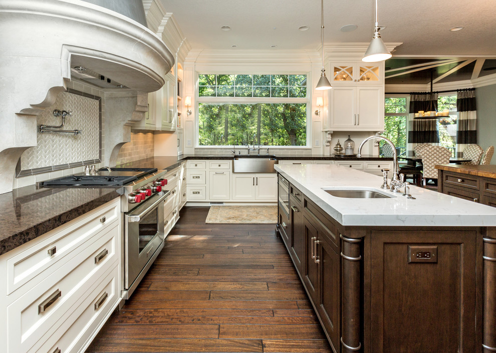 Exempel på ett klassiskt kök, med en rustik diskho, luckor med infälld panel, vita skåp, beige stänkskydd, stänkskydd i tunnelbanekakel och rostfria vitvaror